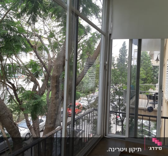 תריסים לבנים על חלון זכוכית במרפסת